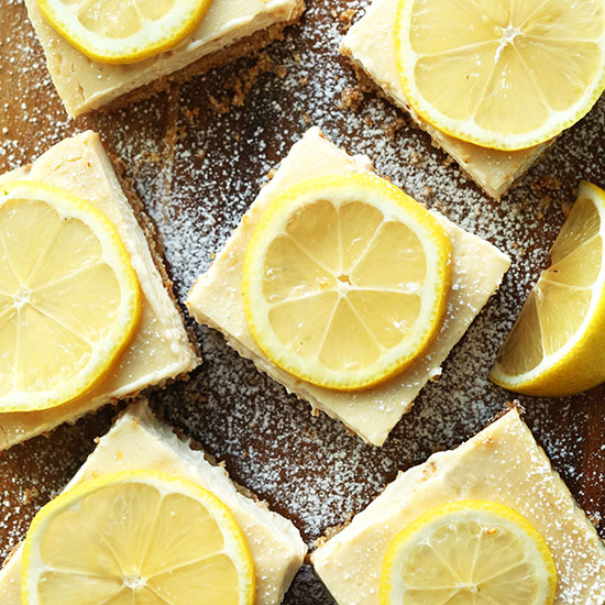 Batch of Creamy Vegan Lemon Bars topped with lemon slices and powdered sugar